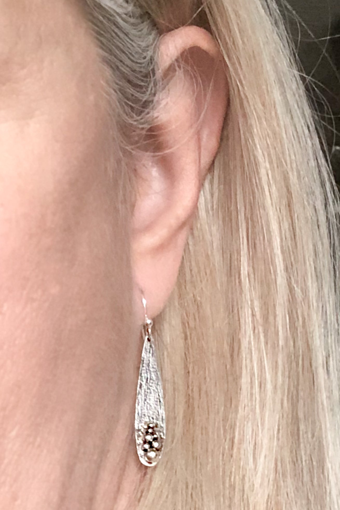 textured sterling silver teardrop earrings on model